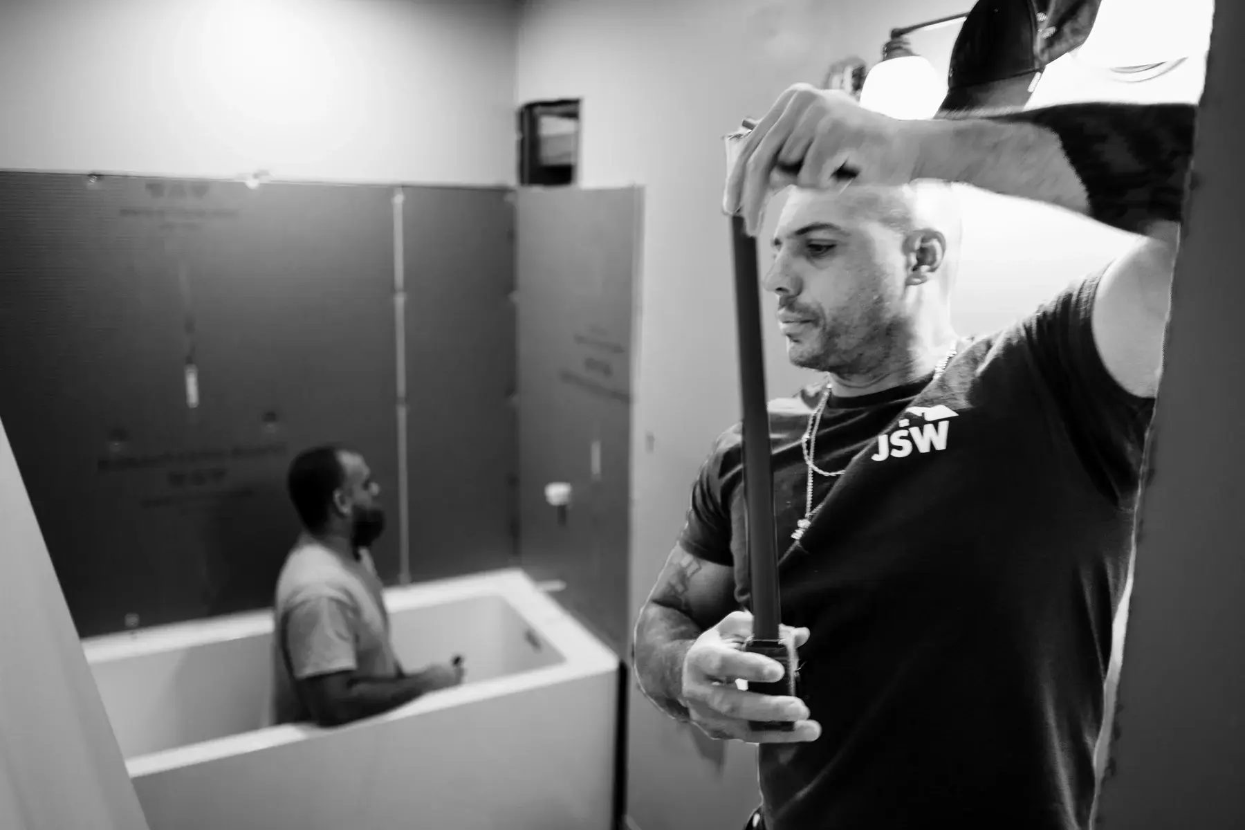 JSW crew members working through bathroom remodeling steps around a tub