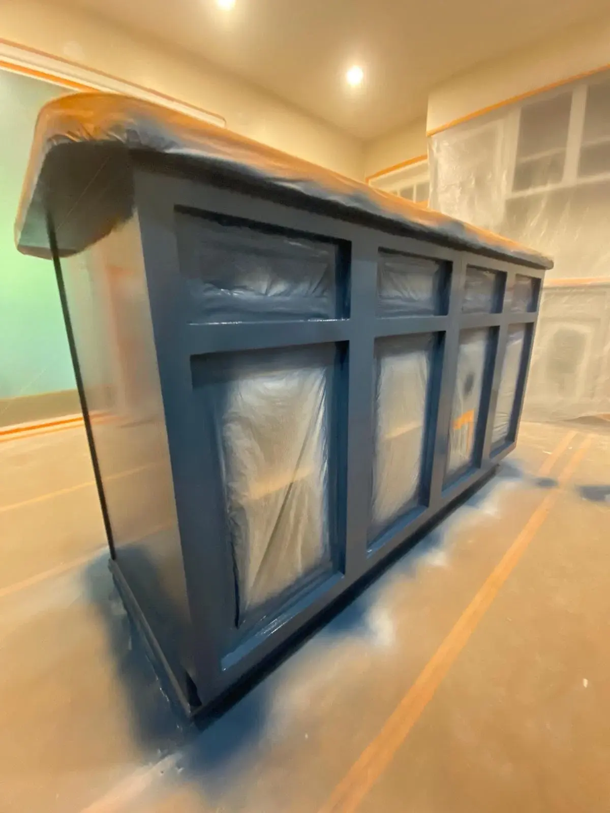 Painted deep-blue kitchen island with coordinated surrounding cabinetry