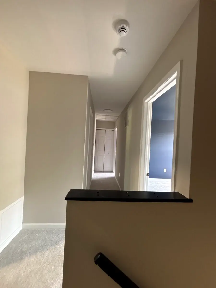Neutral hallway color connecting adjacent rooms and trim