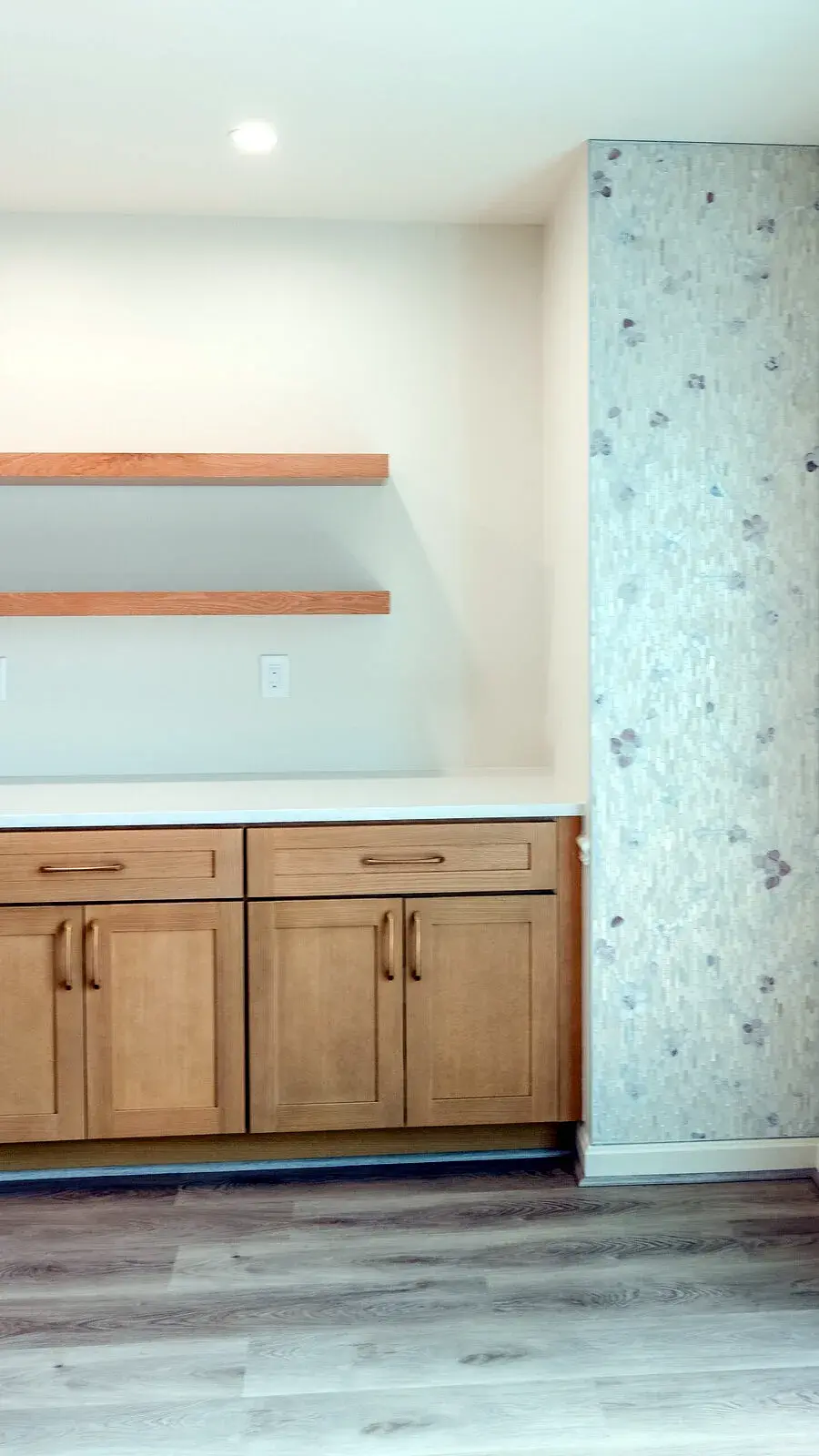 Natural wood cabinet wall with open shelving and full-height tile