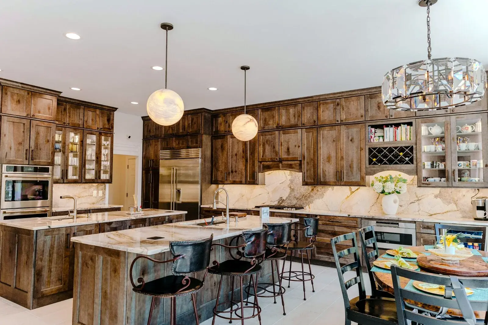 Finished kitchen with warm wood cabinetry, large island, and layered lighting
