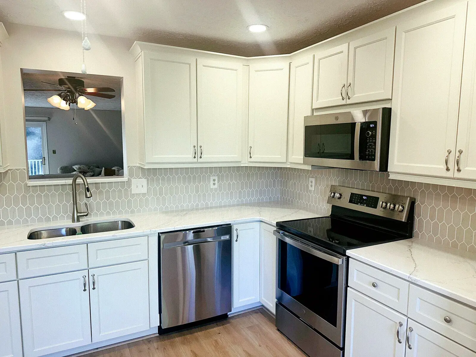 Finished white kitchen with patterned backsplash and stainless appliances