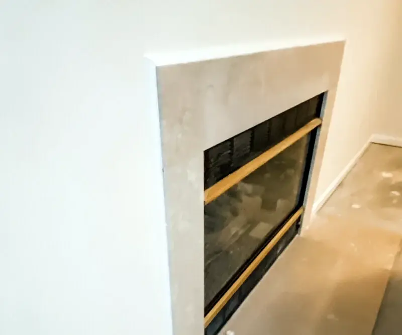 The same fireplace wall rebuilt, finished, and prepared for the room