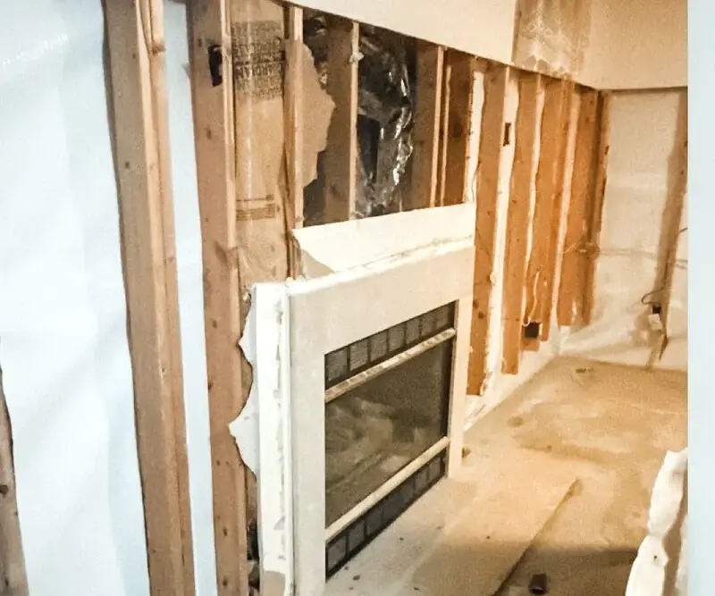 Fireplace wall opened for drywall rebuilding and surface repair