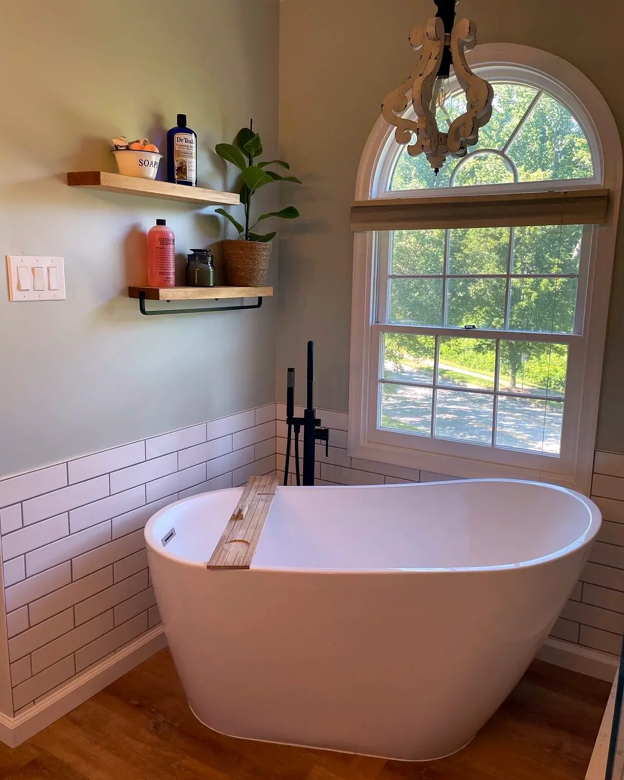 Finished bathroom with freestanding tub, tile wainscot, and open shelving