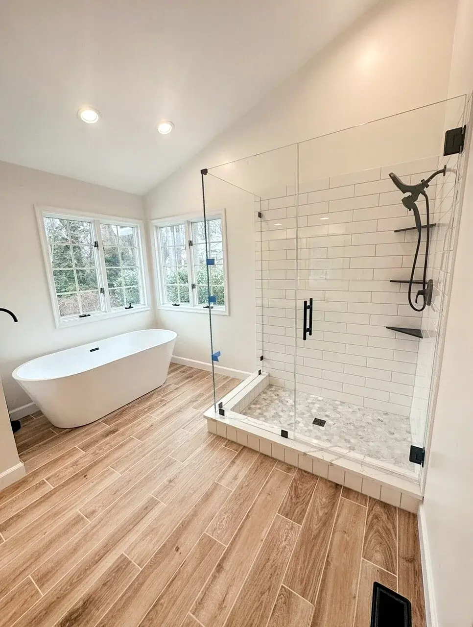 Completed bathroom with coordinated tub, shower tile, flooring, and fixtures
