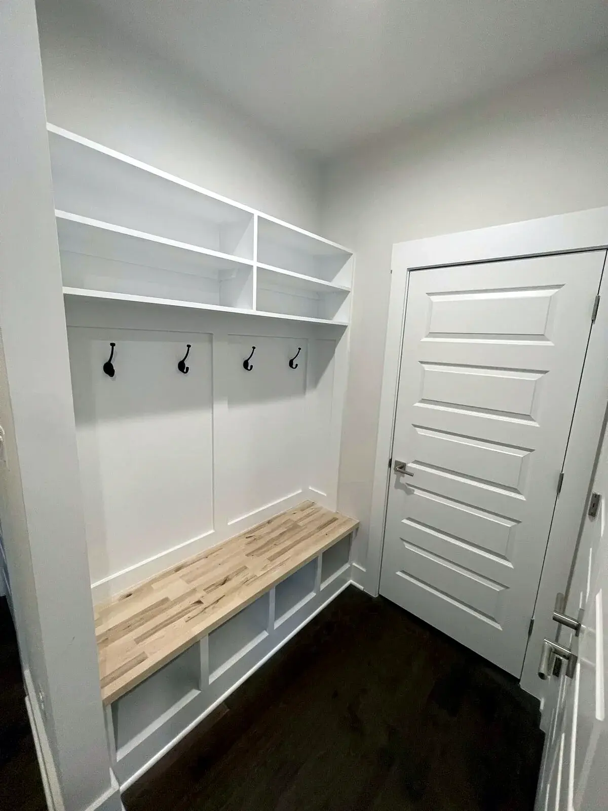 Finished mudroom bench with hooks, shelving, and built-in storage