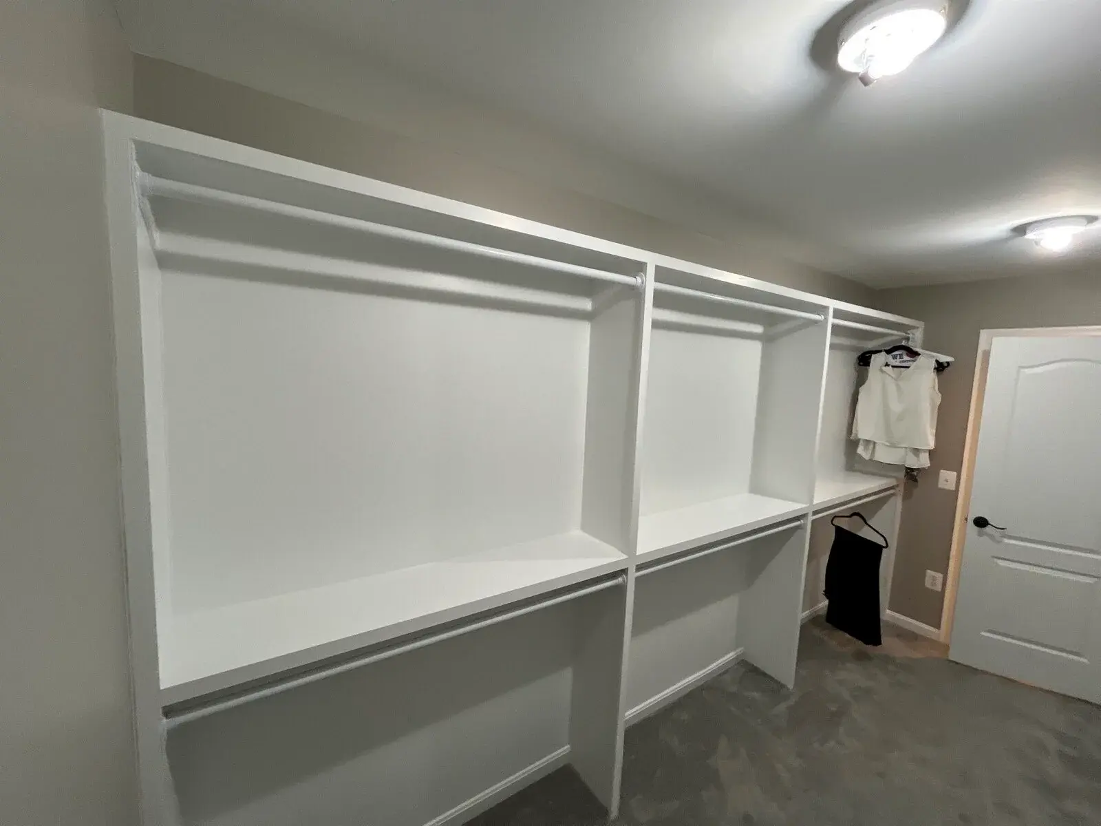 Open closet with built-in hanging rails and upper shelves