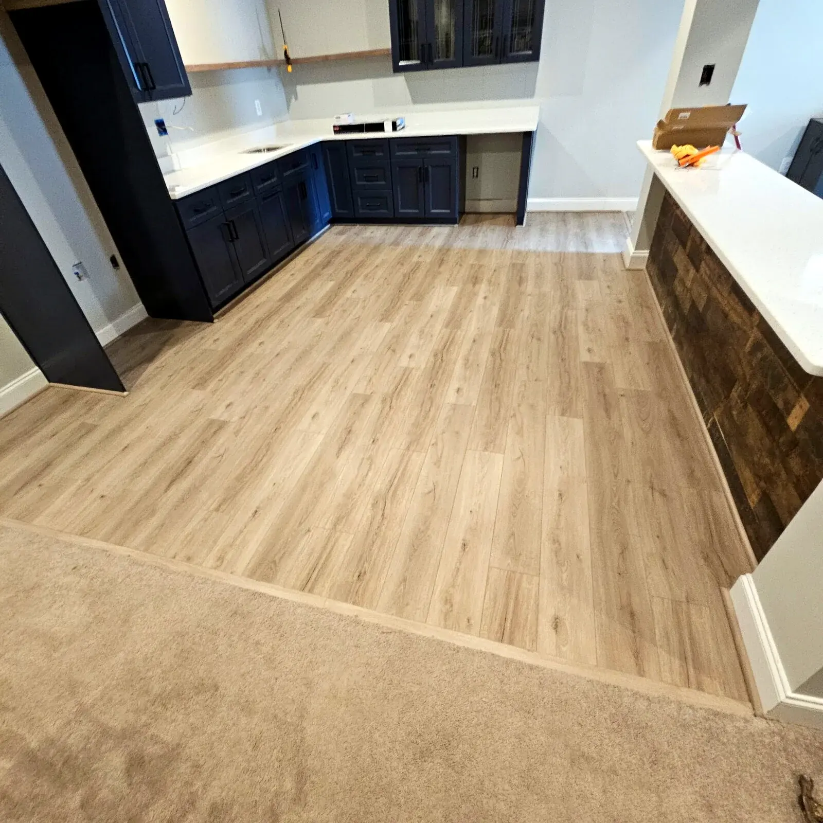 Finished flooring transition from carpet into a kitchen designed for everyday traffic