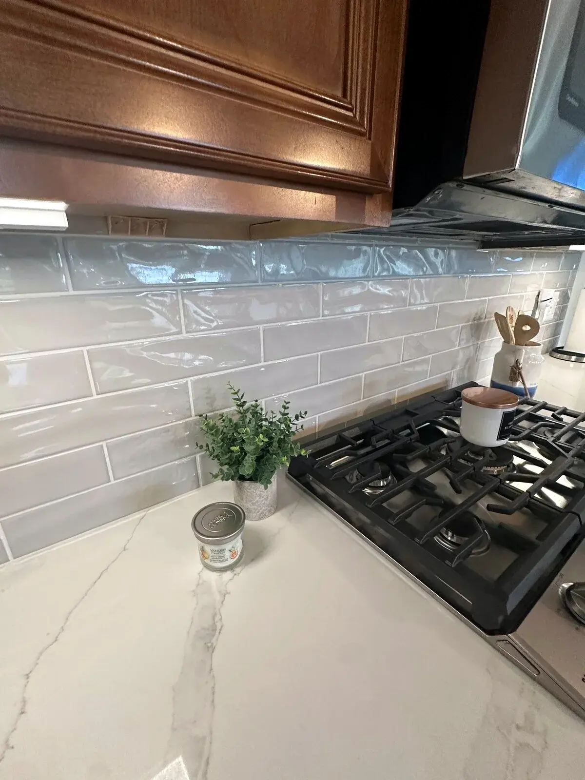 Finished glossy kitchen backsplash with aligned grout lines and clean cabinet transitions