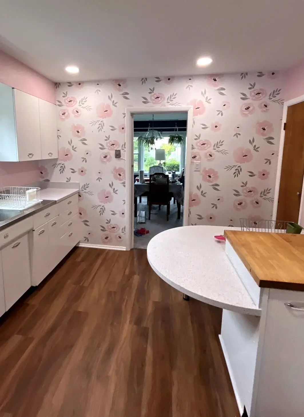 Finished kitchen with soft floral wallpaper around the cabinetry and counters