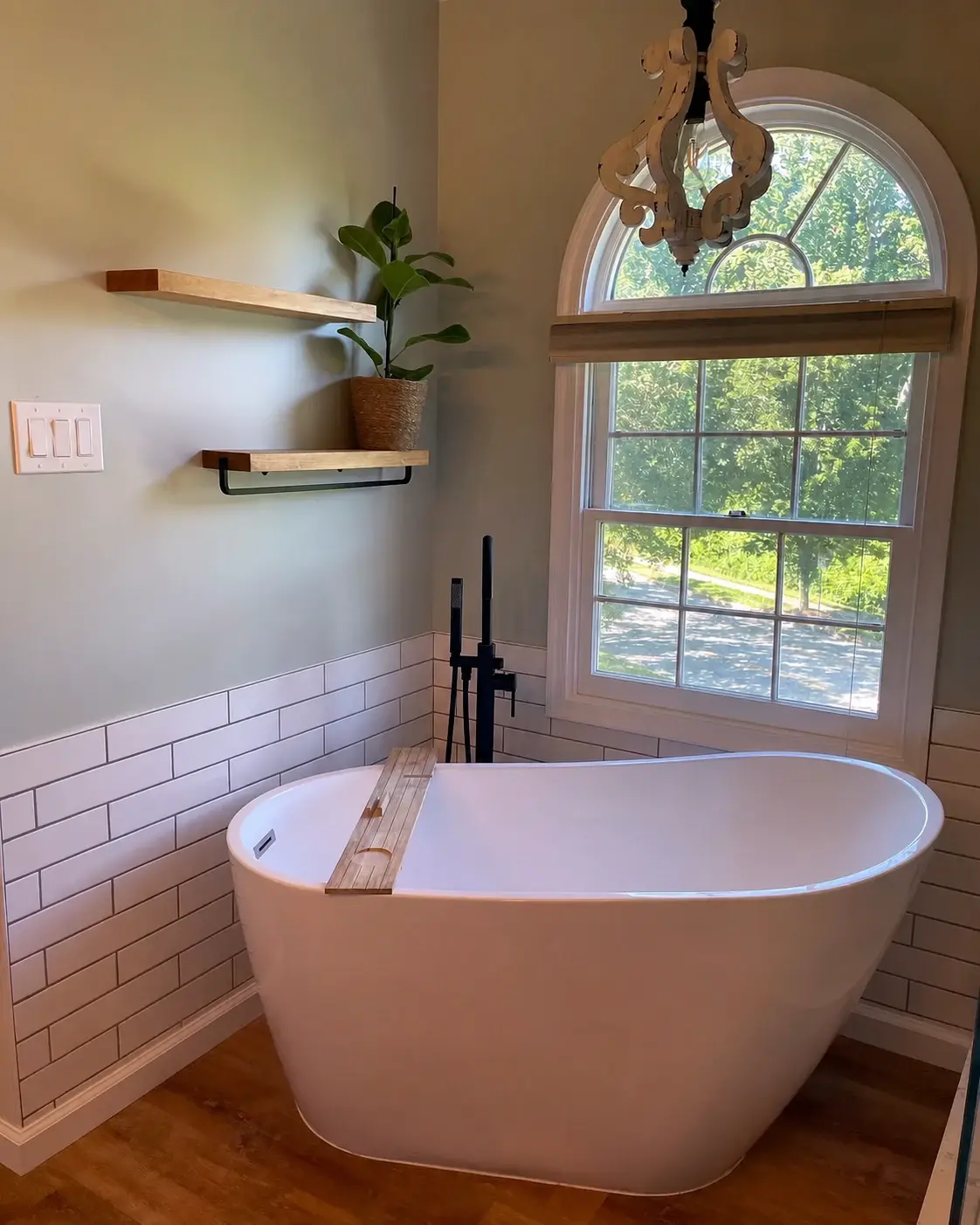 Finished bathroom with freestanding tub, tile wainscot, and open shelving