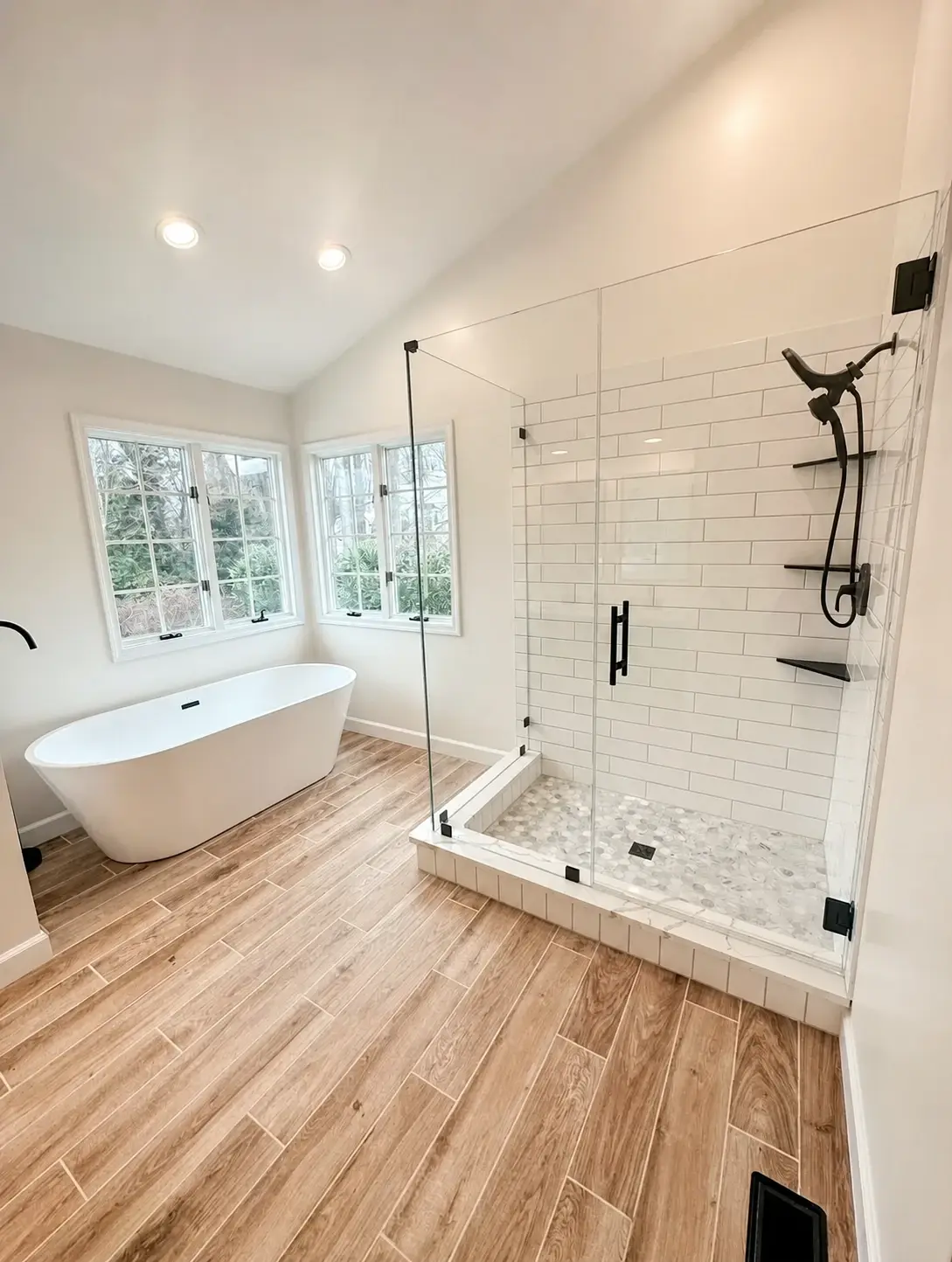 Completed bathroom with coordinated tub, shower tile, flooring, and fixtures