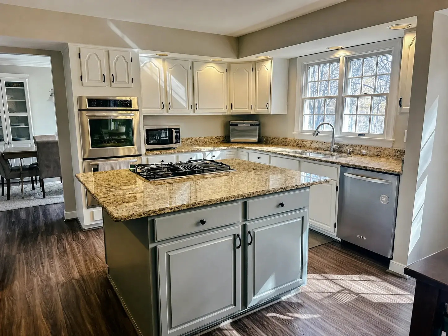 Finished kitchen with soft gray painted cabinetry and a coordinated island