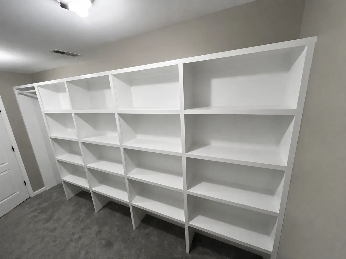 Full wall of finished built-in shelving showing fitted carpentry and clean edges