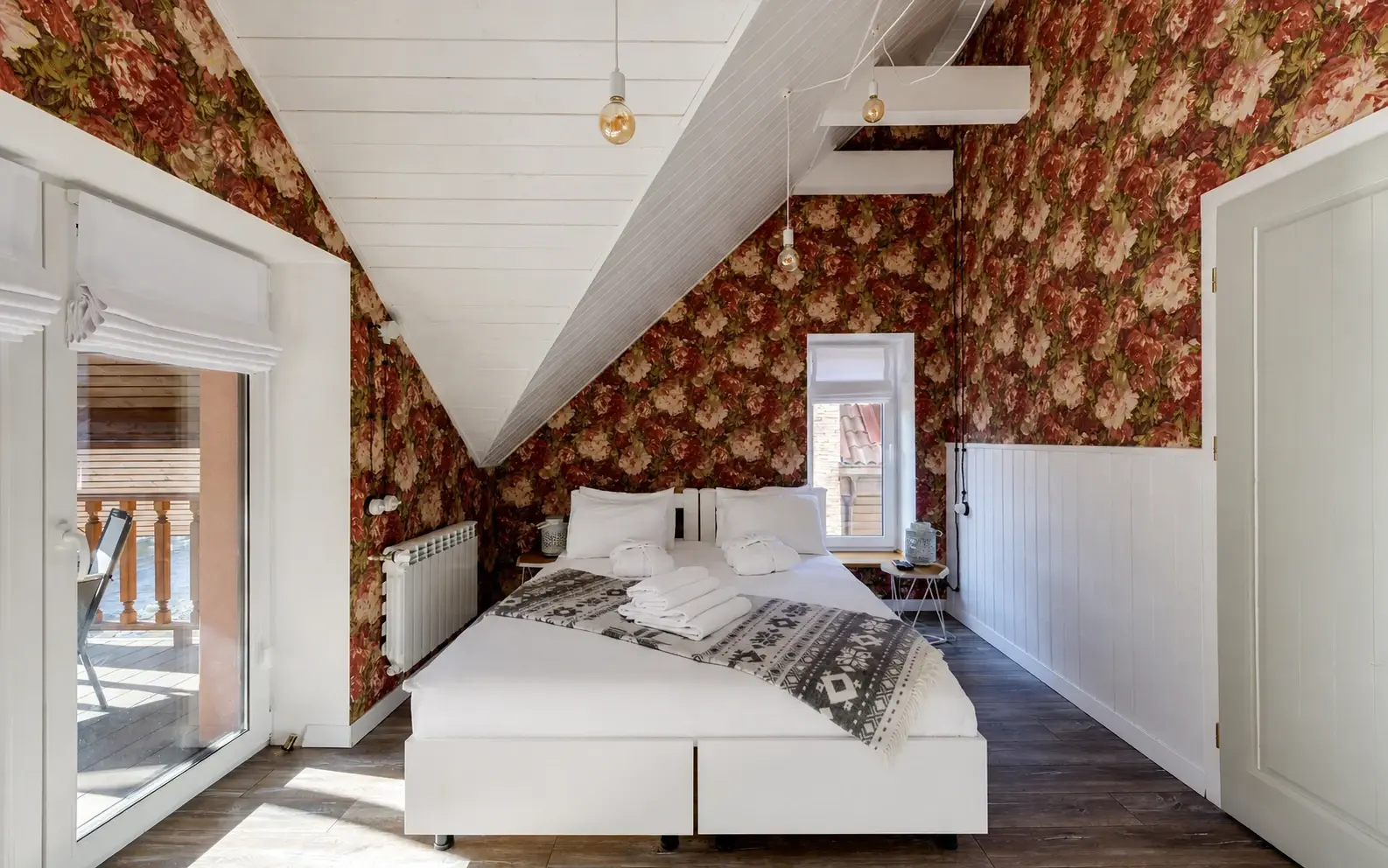 Finished attic bedroom with a clearly sloped ceiling and visible wood-look flooring