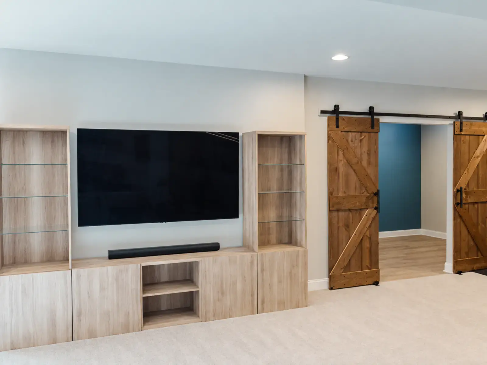Finished basement media wall with fitted storage and a mounted television