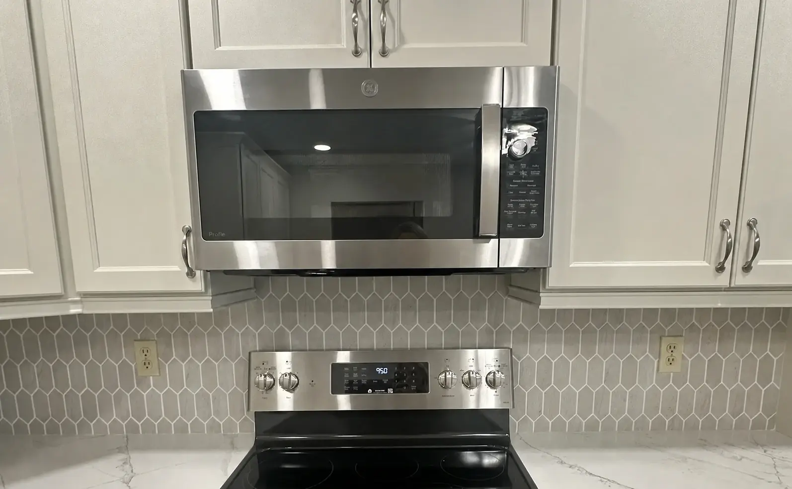 Finished kitchen with full-height wall tile aligned around the range and cabinetry