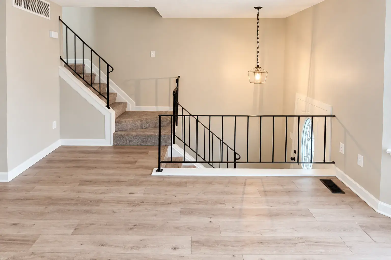 Finished Open Main Level. Continuous plank flooring connects the open living space, with neat edges at the walls and adjoining rooms.