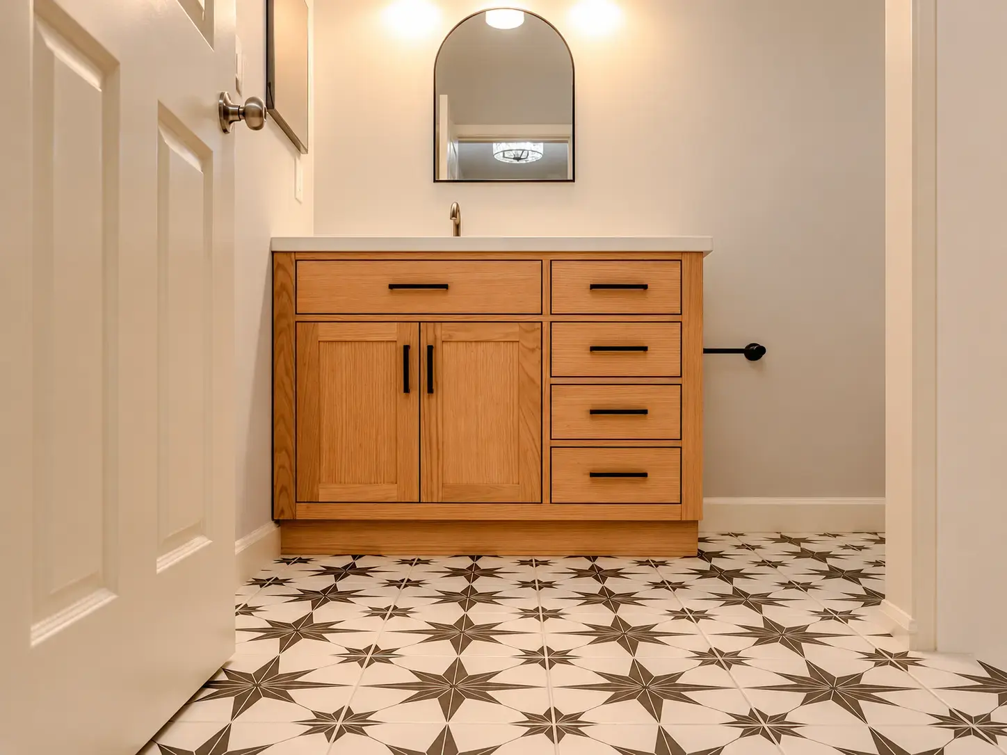 Finished bathroom vanity and distinctive patterned tile floor in a clean completed room