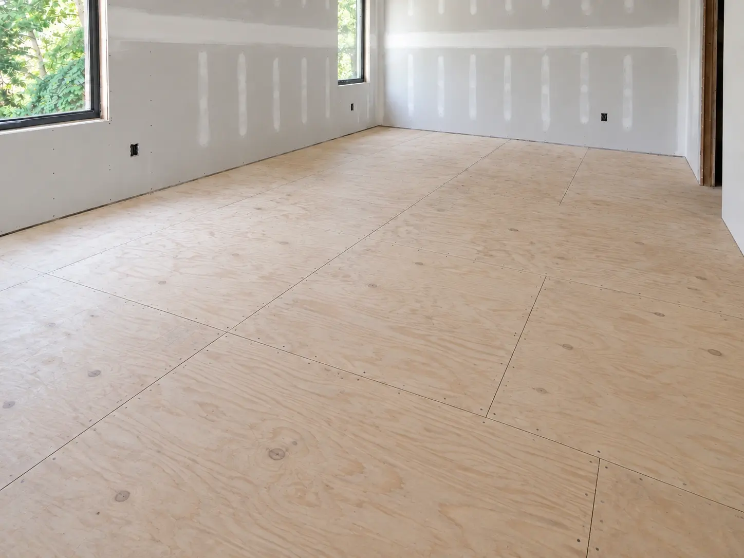 Unfinished plywood floor panels in a room ready for flooring