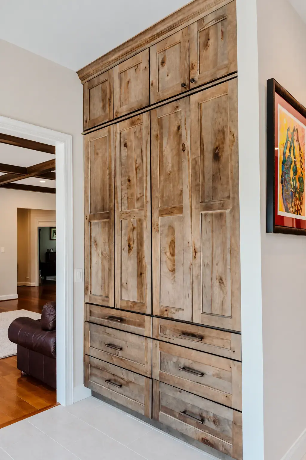 Natural wood full-height cabinetry with drawers and tall doors fitted into a recessed wall