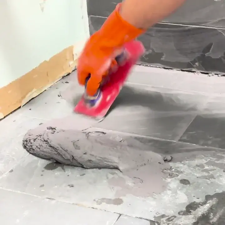 Applying grout across tiled-floor joints