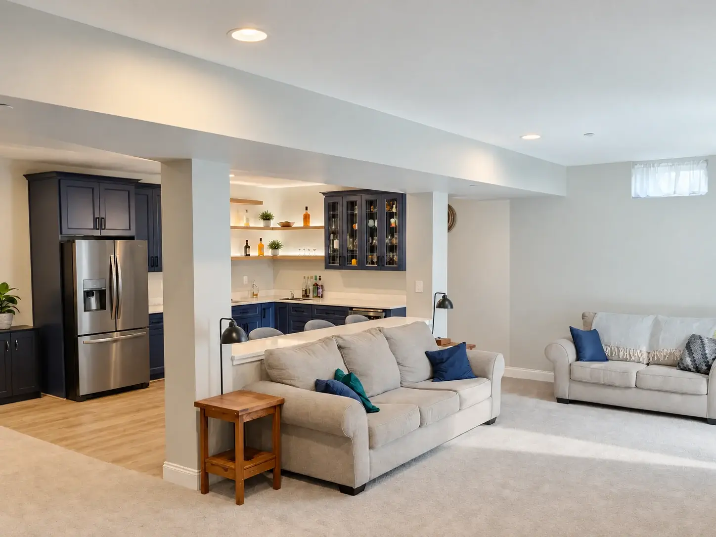 Finished lower-level lounge with carpet beside a hard-surface bar area