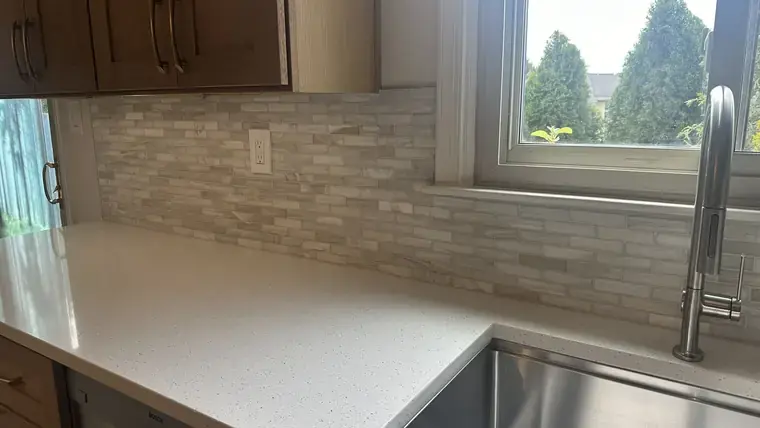 Kitchen sink, counter, and linear tile backsplash detail