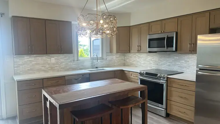 Warm wood kitchen cabinets, central island, and pendant lighting