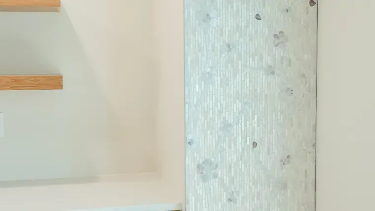 Light kitchen tile feature wall with floating wood shelves