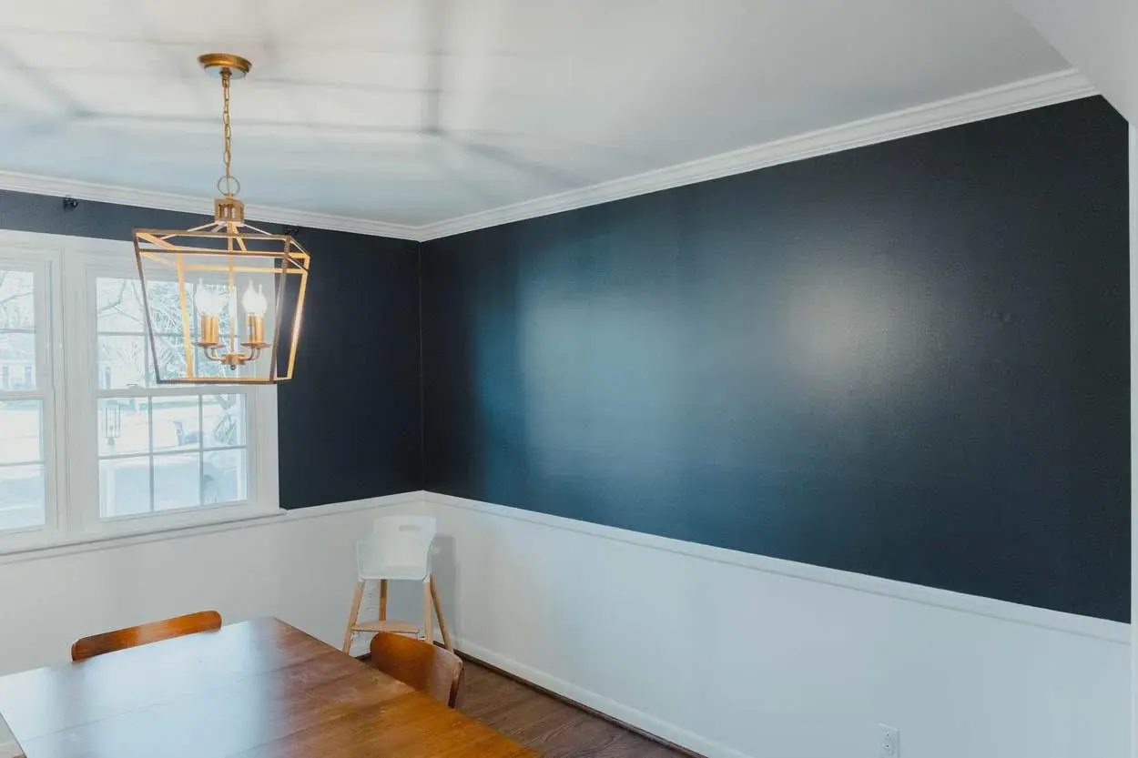 Finished dining room with a deep painted accent wall and bright trim