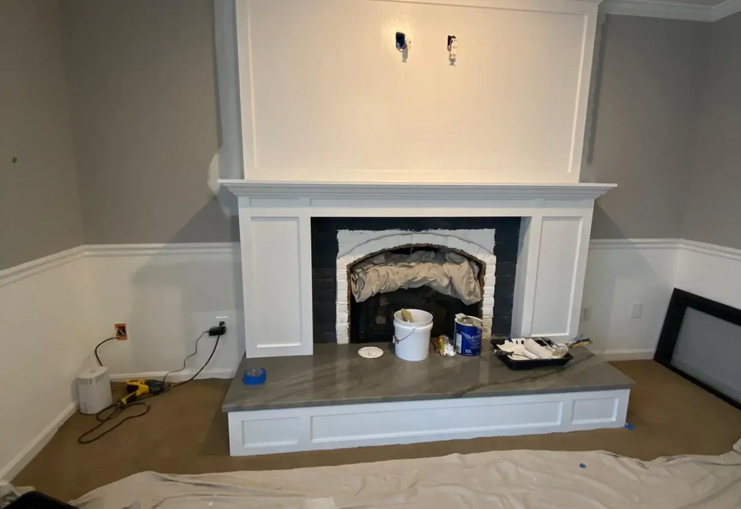 Fireplace surround carpentry with measured panel, mantel, and hearth details during finish work