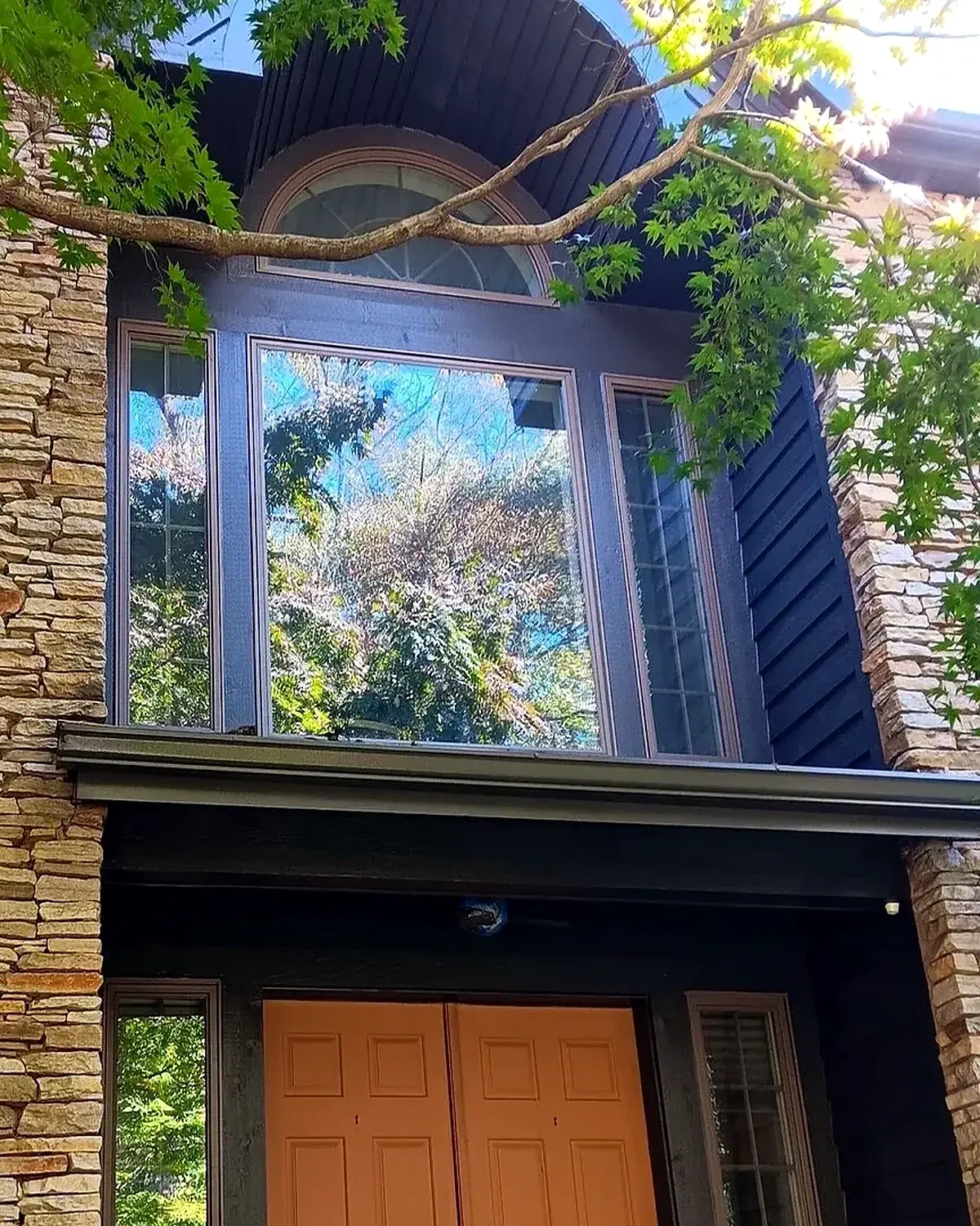 Finished dark exterior entry with warm wood doors and crisp painted trim
