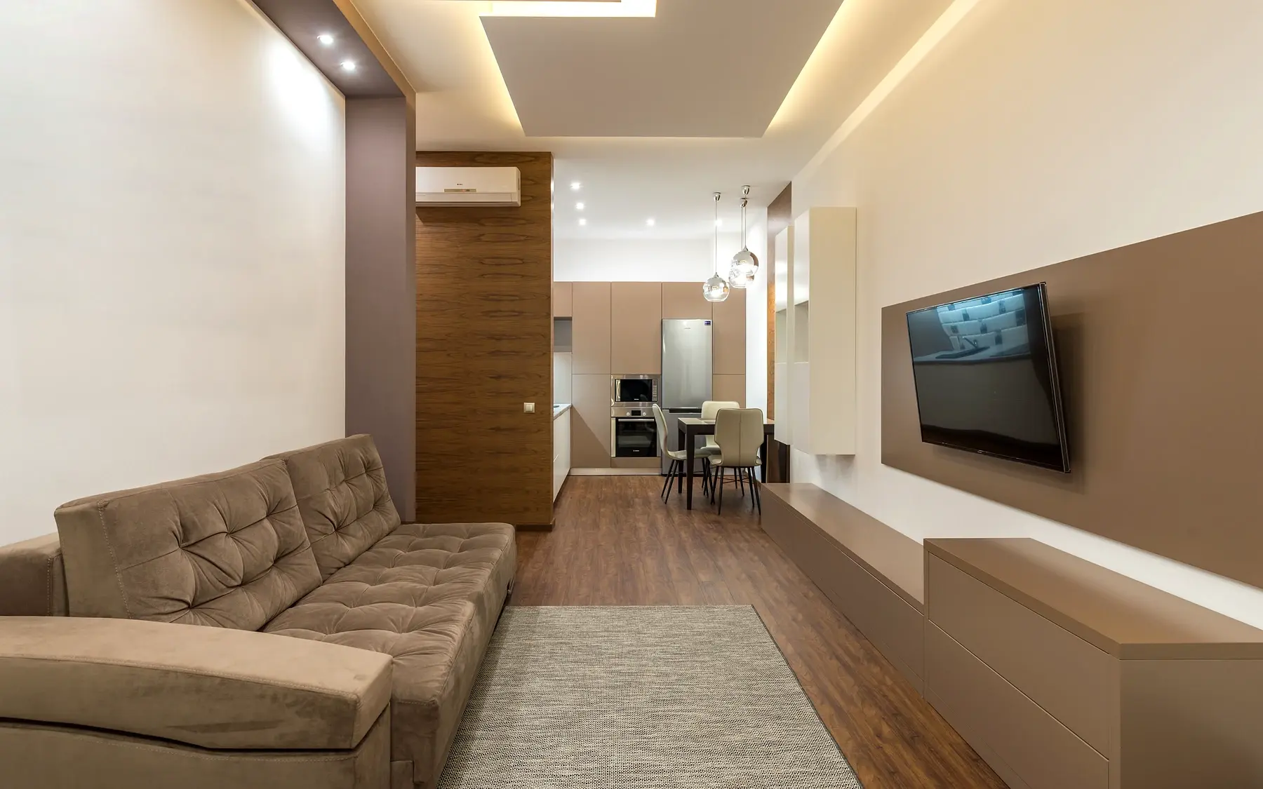 Finished open living room with continuous warm wood-look flooring through the connected space